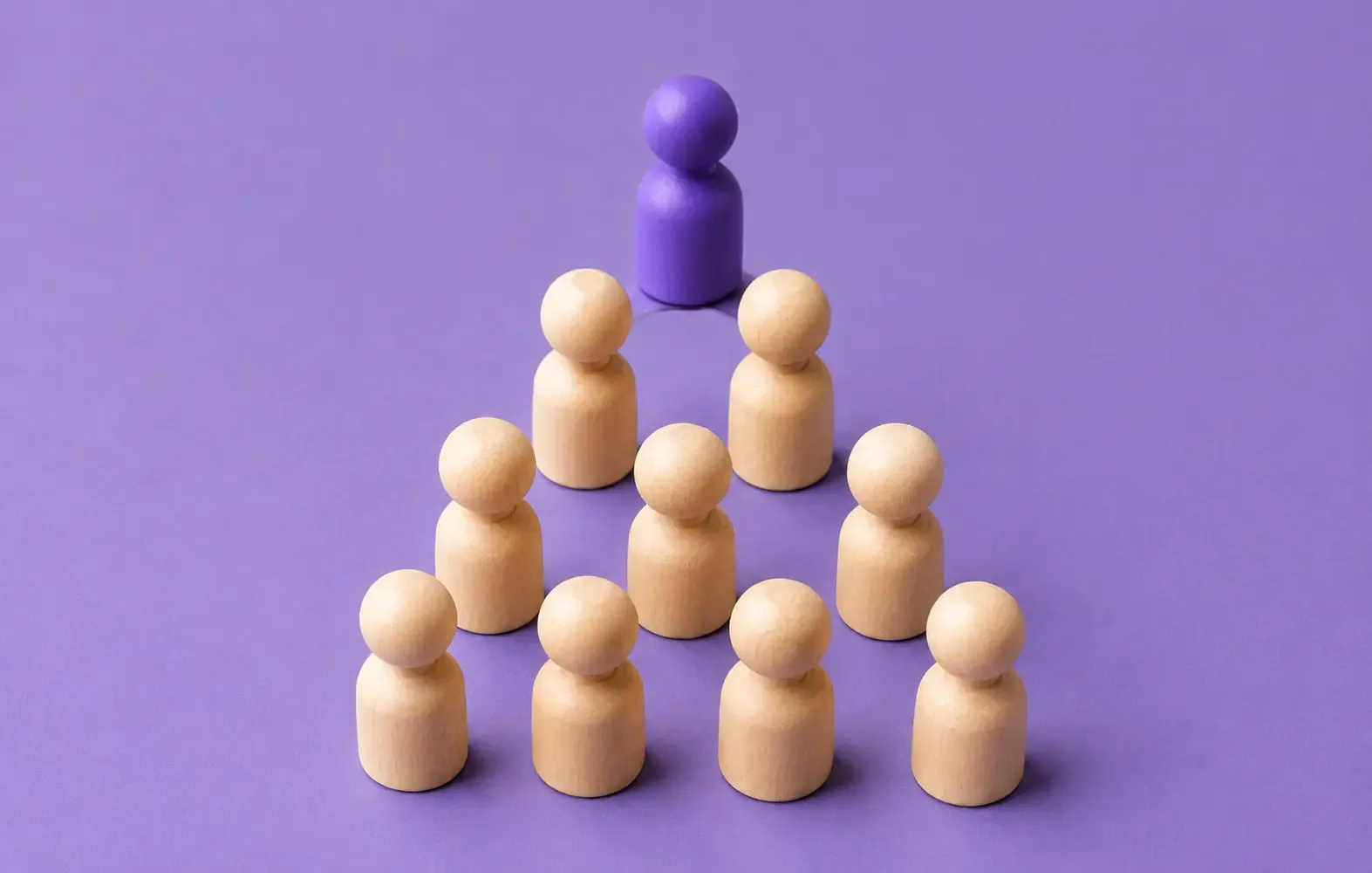 Purple peg figure above a group of wooden figures representing lead scoring and lead prioritization.